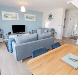 A living room with sofas a television and a dining table at 14 Parc Delfryn Brynteg near Benllech