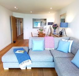 A living room with a sofa and a table at Sea Mist in Carbis Bay