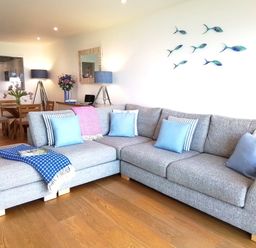 A living room with a sofa and dining area at Sea Mist in Carbis Bay