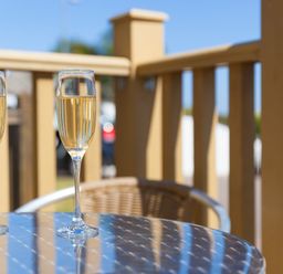 Two glasses of champagne on a round metal table on a balcony at Gennaker in Carbis Bay
