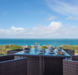 An outdoor dining area with a table set for tea at Halcyon Cove in Carbis Bay