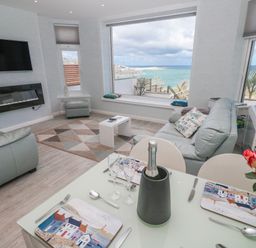 A living room with a sofa and dining table at Island View in Carbis Bay