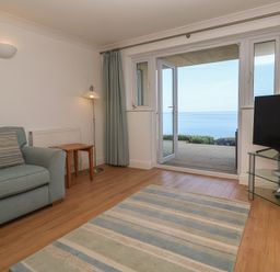 A living room with a sofa and a tv at Sapphire in Carbis Bay