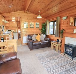 A living room with a sofa and dining table at Squirrels Leap near Number 29, Burnside Park near Keswick