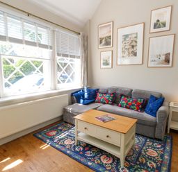 A living room with a sofa and coffee table at Sea Pink Cottage in Langton Matravers