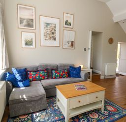 A living room with a sofa and coffee table at Sea Pink Cottage in Langton Matravers