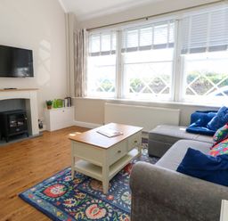 A living room with a sofa and coffee table at Sea Pink Cottage in Langton Matravers