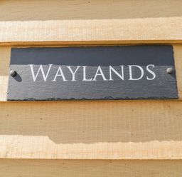 A sign with the word Waylands on a wooden surface at Waylands in Uffington