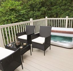 An outdoor deck with black wicker chairs a glass table and a hot tub at Number 43 Burnside Lodge in Felton