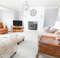 A living room with armchairs a television and a fireplace at 12 Claremont Falls in Polperro