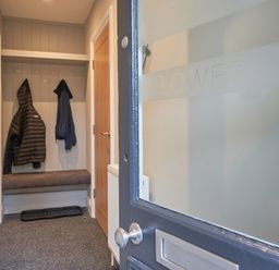 An entryway with coats hanging on hooks and a bench at Lower Sheriff's Place Windermere