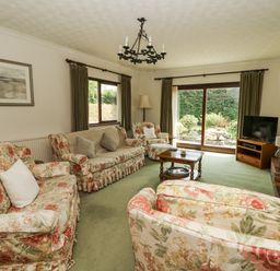 A living room with floral furniture and a television at Kala Spittal near Haverfordwest