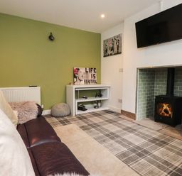 A living room with a sofa and a fireplace at Tyddyn Elidir near Old Colwyn