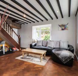 A living room with a black sofa and coffee table at Tyddyn Elidir near Old Colwyn