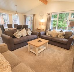 A living room with two sofas a coffee table and a dining table with chairs at Cherry Tree Lodge Calgarth 37 White Cross Bay near Windermere