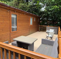 An outdoor area with a wooden cabin and seating at Cherry Tree Lodge, Calgarth 37, White Cross Bay near Windermere