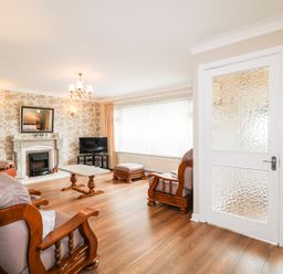 A living room with wooden furniture a coffee table a fireplace and a TV at 27 Pinewood Hill Warrenpoint Northern Ireland