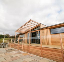 Outdoor patio area with wooden deck and pergola at Stables Lodge in Wingerworth