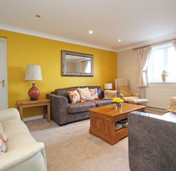 A living room with sofas coffee table lamp and window at Wheal Kendall in Mevagissey