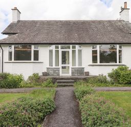 A front view of a single-story house with a pathway and garden at Halewood in Bowness-On-Windermere