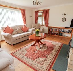 A living room with sofas a wooden coffee table and a bookcase at Rose Bank in Belford