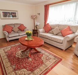 A living room with sofas a wooden coffee table and a patterned rug at Rose Bank in Belford