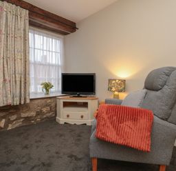 A living room with a television and armchair at Beck View