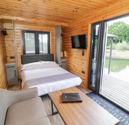 A bedroom with a bed and a sofa at Oak Lodge At Bridge Lake Farm & Fishery, Chacombe