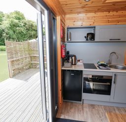 A kitchen with appliances at Oak Lodge At Bridge Lake Farm & Fishery Chacombe