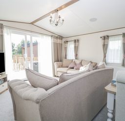 A living room with sofas television and curtains at 22 Sherwood in South Lakeland Leisure Village near Warton