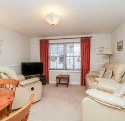 A living room with a sofa and television at Derwent Haven in Keswick