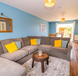 A living room with a sofa and coffee table at Cae Berllan in Mynytho near Pwllheli