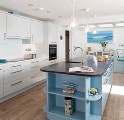A kitchen with an island counter and seating area at The White House Polzeath