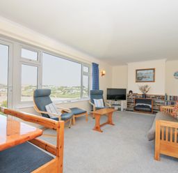 A living room with furniture and ocean view at Zapadiah in Polzeath