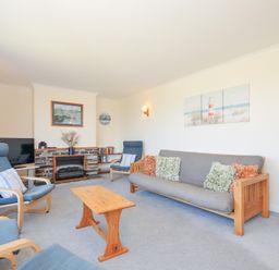 A living room with seating and television at Zapadiah in Polzeath