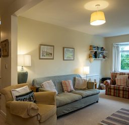 A living room with sofas cushions lamps bookshelves and framed pictures at Pencreek in Rock