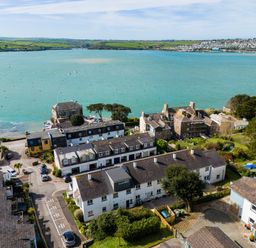 Aerial view of houses near a body of water with hills and a town in the background at Slipway 7 Rock