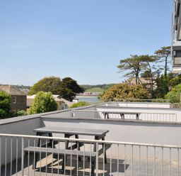 An outdoor terrace with a table and benches overlooking trees and distant buildings at Slipway 16 in Rock