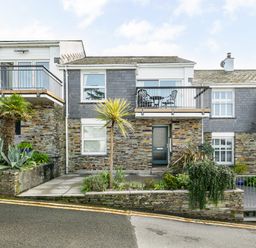 A stone and slate house with balconies and plants in front at Slipway 21 in Rock