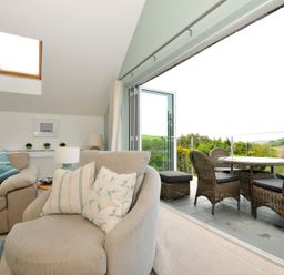 A living room with a sofa and armchair at Farlands in Daymer Bay