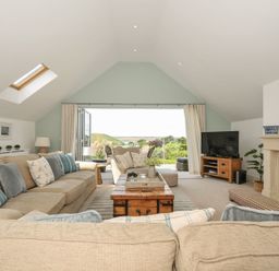 A living room with a sofa and coffee table at Farlands in Daymer Bay