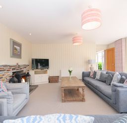 A living room with a coffee table and fireplace at Porthilly Brook in Rock