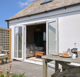 An outdoor area with a table and chairs at Cartway Cabin in Port Isaac