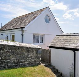 A house with a shed and stone wall at Cartway Cabin Port Isaac
