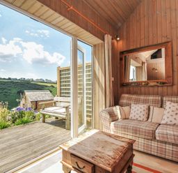 A living room with a sofa and coffee table at Cartway Cabin Port Isaac