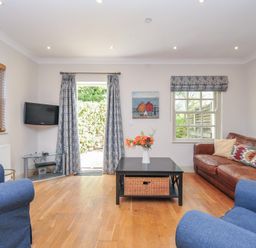 A living room with a television and seating area at Lowenna Manor 10 Rock