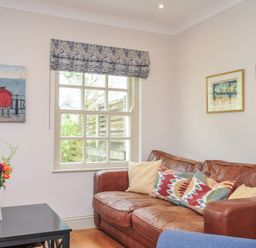 A living room with a sofa and a table with flowers at Lowenna Manor 10 Rock