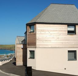A street view of a modern house near the coast with a road leading to the beach at The Beach Hut in Polzeath