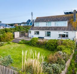 A house with a fenced garden and shrubs at Bella Vista in Polzeath