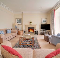 A living room with sofas a fireplace a television and a coffee table at The Haven in Daymer Bay